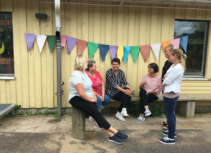 pedagoger sitter på bänk på förskolegård