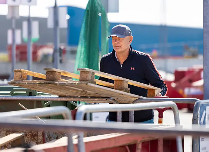 Man sorterar grovavfall i en container på Återbruket Kikås
