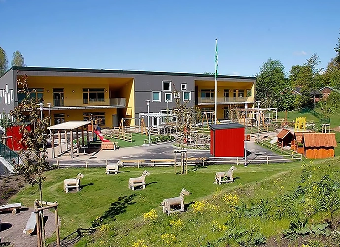 förskolegård med trähästar framför förskolan