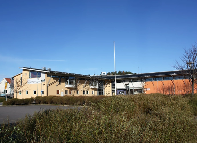 Framsida skola med buskar i förgrunden