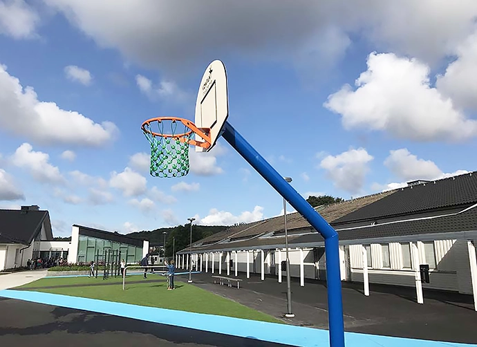 Skolgård med basketkorg i förgrunden
