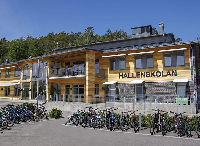 gul skolbyggnad med cykelställ med cyklar i förgrunden