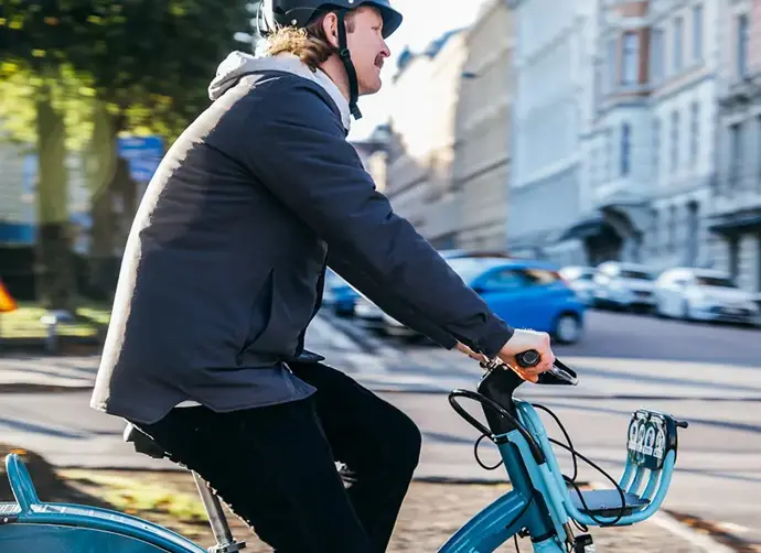 En man cyklar inne i en stad.
