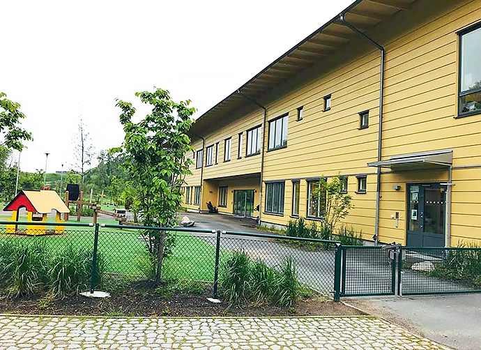 Förskolegården och den gula förskolan i bakgrunden