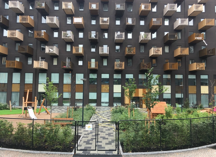 grind och gång fram till förskola i bottenvåning till högt hus med balkonger