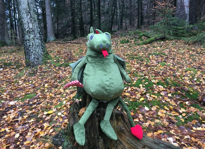 Drakdocka sitter på en stubbe i skogen