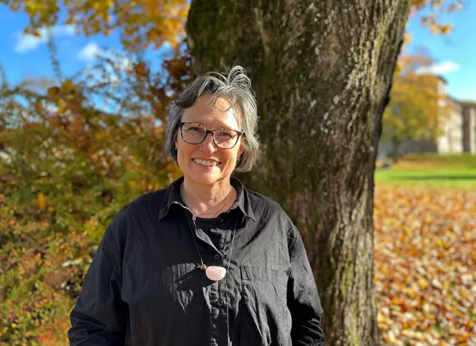 Alice de Jesus Kozakevicius, lektor i matematik står framför ett träd och höstlöv.