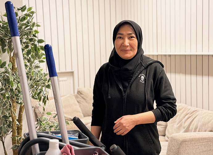 Kvinna står vid en städvagn.