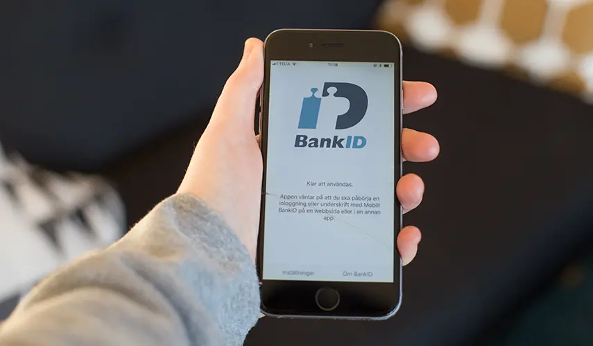 Bild på en hand som håller i en iPhone med appen BankID öppen.