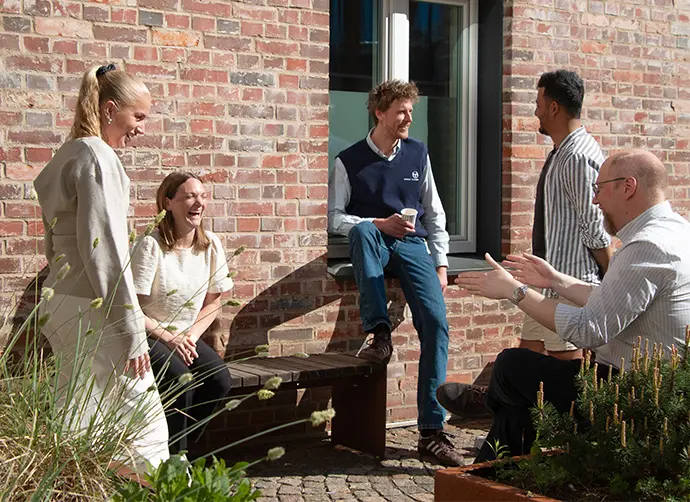 En grupp elever står utomhus och pratar.
