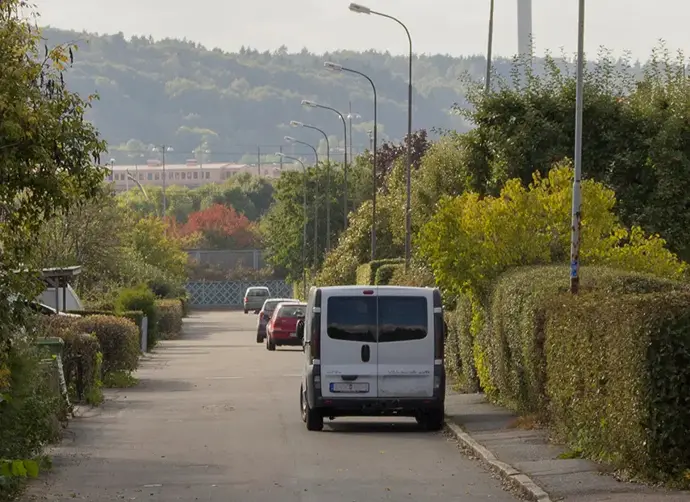 En gata med flera bilar parkerade längs med trottoaren