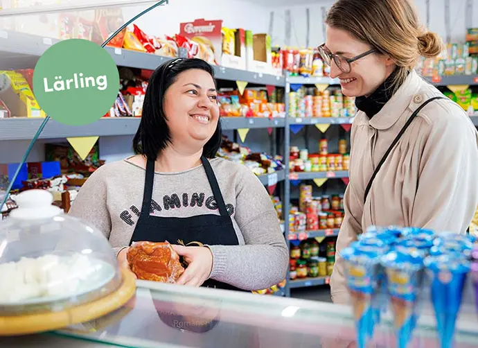 En kvinnlig säljare pratar med en kund i en butik.