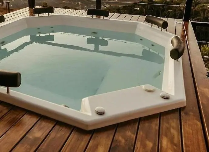 Ett vattenfylld jacuzzi som är nedsänkt i en altan.