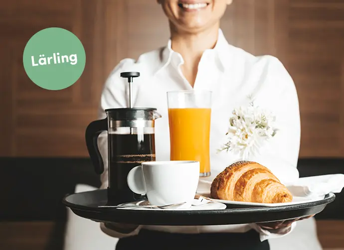 En person serverar frukost på en bricka.