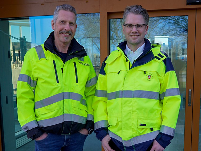 Platschef Peter Höjer från Vestia och Ludwig Nöjd, projektledare i Mölndals stad, skakar hand utanför entrén till Åbybadet