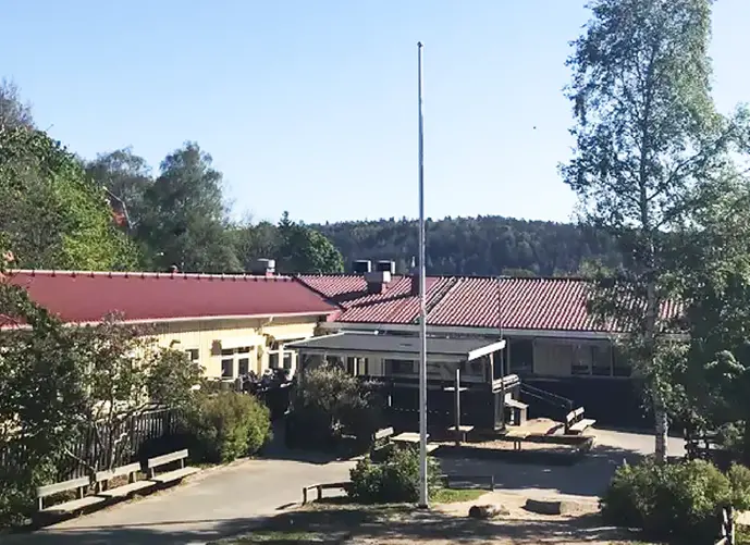 gård med flaggstång och förskolan i bakgrunden
