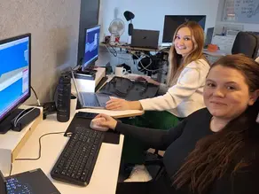 Två tjejer sitter framför varsin dator.