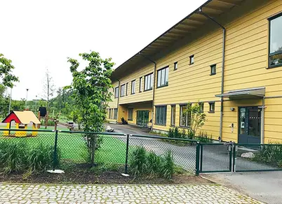 Förskolegården och den gula förskolan i bakgrunden