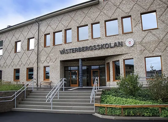 trappa upp till entré på skolbyggnad i gult tegel