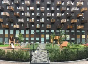 grind och gång fram till förskola i bottenvåning till högt hus med balkonger