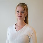 Susanna har uppsatt rött hår, vit tröja och ler lätt mot kameran.