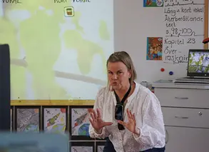lärare står framför tavlan i klassrummet